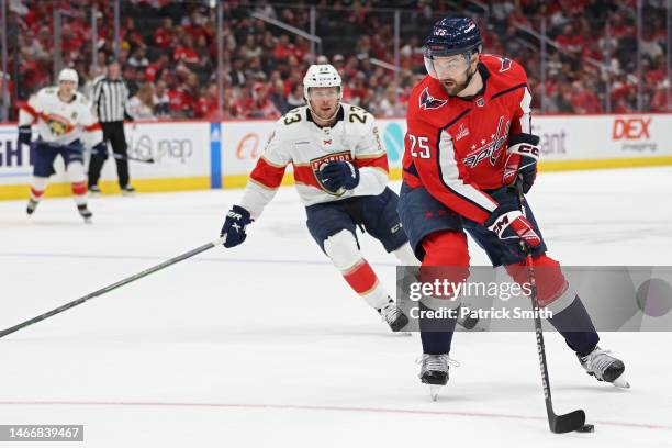 Dylan McIlrath of the Washington Capitals skates past Carter Verhaeghe of the Florida Panthers during the first period at Capital One Arena on...