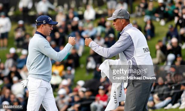 Justin Thomas of the United States and caddie Jim "Bones" Mackay celebrate on the 18th green during the first round of the The Genesis Invitational...