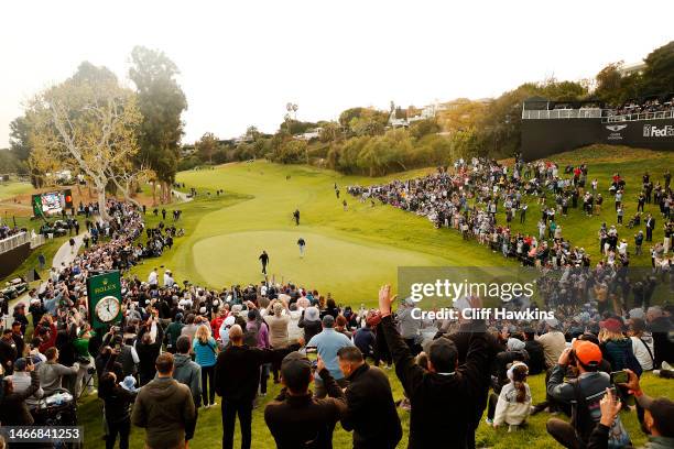 General view as Tiger Woods of the United States putts on the 18th green during the first round of the The Genesis Invitational at Riviera Country...