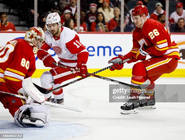 Filip Zadina of the Detroit Red Wings battles Michael Stone and goaltender Dan Vladar of the Calgary Flames in front of the net against the at the...