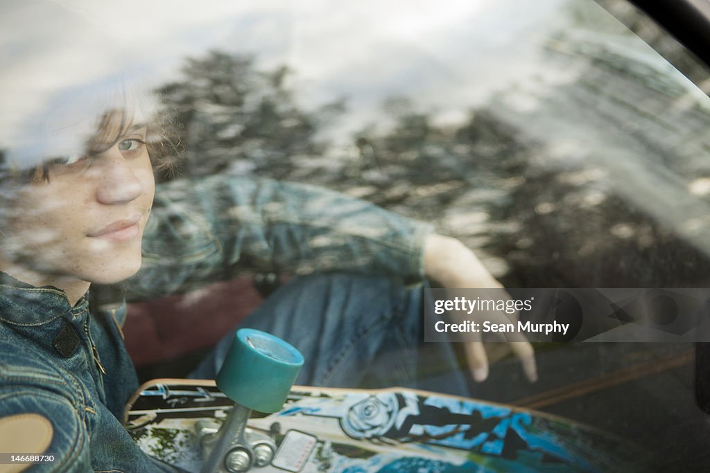 Teenage Boy in Car with Skate Board