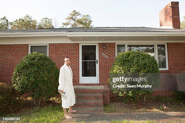 man wearing bathrobe outside his home - robe stock pictures, royalty-free photos & images