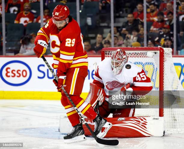 Magnus Hellberg of the Detroit Red Wings blocks the puck behind Dillon Dube of the Calgary Flames in the third period at the Scotiabank Saddledome on...