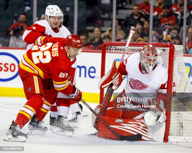 Trevor Lewis of the Calgary Flames crashes the crease against Olli Maatta and goaltender Magnus Hellberg of the Detroit Red Wings in the third period...