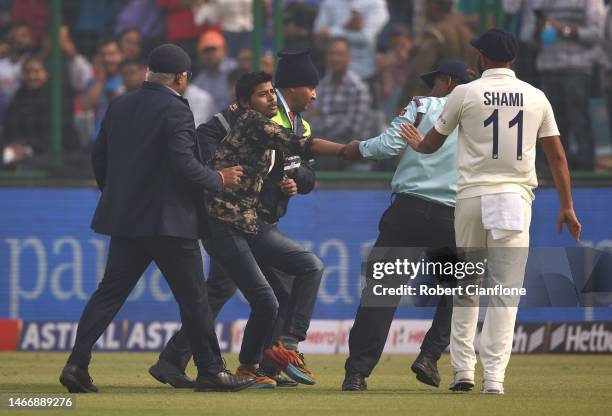 Pitch invader is seen pleading with Mohammed Shami of India during day one of the Second Test match in the series between India and Australia at Arun...