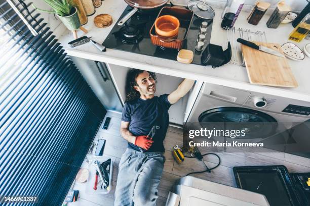 man repairing kitchen. - handyman stockfoto's en -beelden