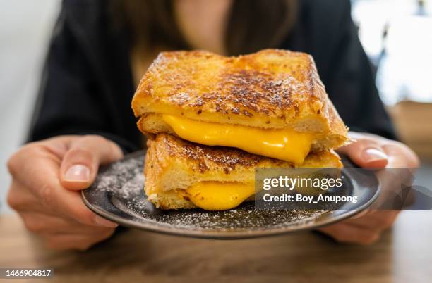 someone holding a cheese toast before eating. - eating cheese stockfoto's en -beelden