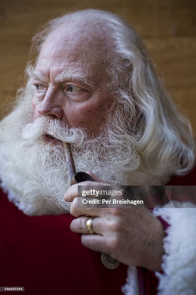 Santa Claus looking pensive, smoking a pipe