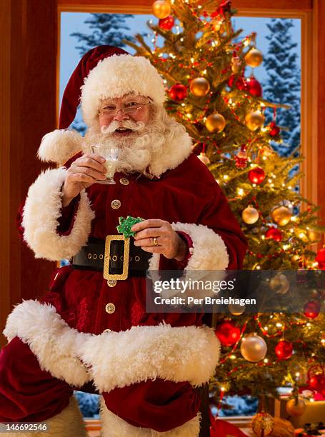 a happy santa claus with milk and a cookie - santa portrait stock pictures, royalty-free photos & images