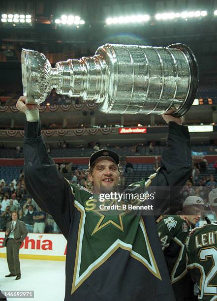 Derian Hatcher of the Dallas Stars celebrates with the Stanley Cup after the Stars defeated the Buffalo Sabres in Game 6 of the 1999 Stanley Cup...