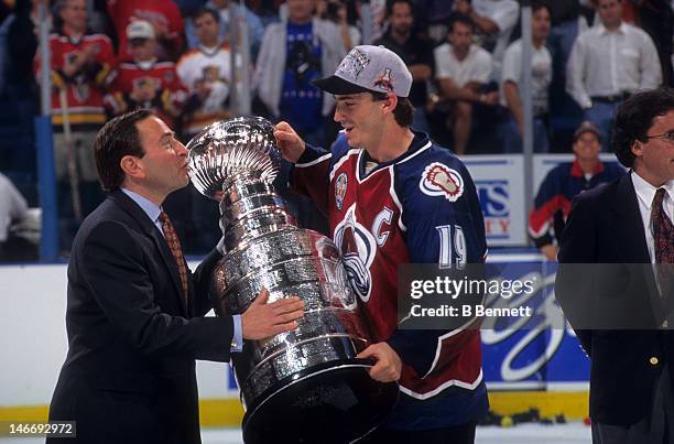 Joe Sakic of the Colorado Avalanche takes the Stanley Cup from NHL commissioner Gary Bettman after the Avalanche defeated the Florida Panthers in...