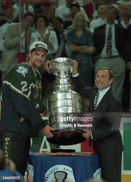 Derian Hatcher of the Dallas Stars takes the Stanley Cup from NHL commissioner Gary Bettman after the Stars defeated the Buffalo Sabres in Game 6 of...