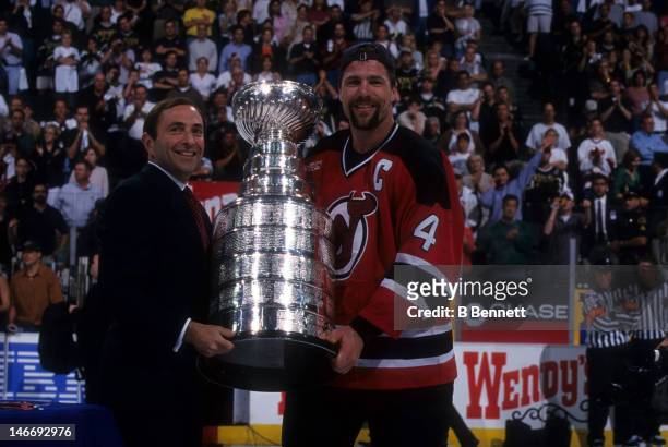 Scott Stevens of the New Jersey Devils takes the Stanley Cup from NHL commissioner Gary Bettman after the Devils defeated the Dallas Stars in Game 6...