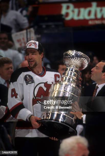 Scott Stevens of the New Jersey Devils takes the Stanley Cup from NHL commissioner Gary Bettman after the Devils defeated the Detroit Red Wings in...