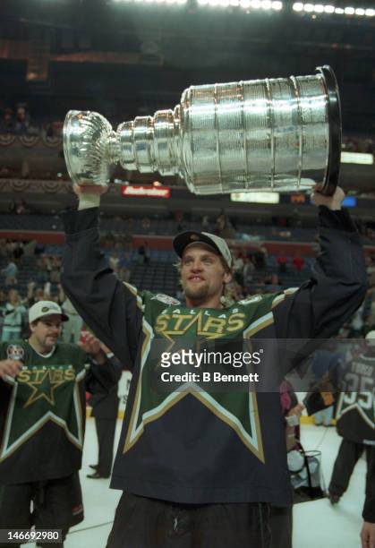 Derian Hatcher of the Dallas Stars celebrates with the Stanley Cup after the Stars defeated the Buffalo Sabres in Game 6 of the 1999 Stanley Cup...