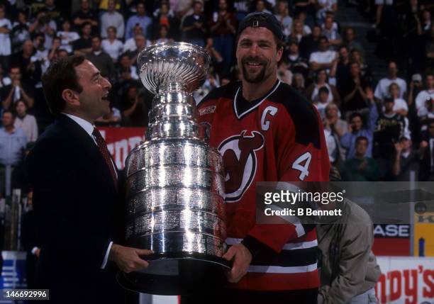 Scott Stevens of the New Jersey Devils takes the Stanley Cup from NHL commissioner Gary Bettman after the Devils defeated the Dallas Stars in Game 6...