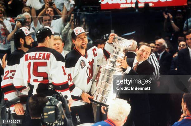 Scott Stevens of the New Jersey Devils takes the Stanley Cup from NHL commissioner Gary Bettman after the Devils defeated the Detroit Red Wings in...
