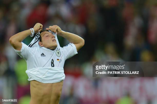 German midfielder Mesut Oezil takes off his jersey at the end of the Euro 2012 football championships quarter-final match Germany vs Greece on June...