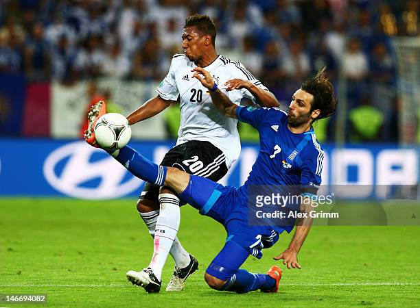 Giorgos Samaras of Greece tackles Jerome Boateng of Germany during the UEFA EURO 2012 quarter final match between Germany and Greece at The Municipal...
