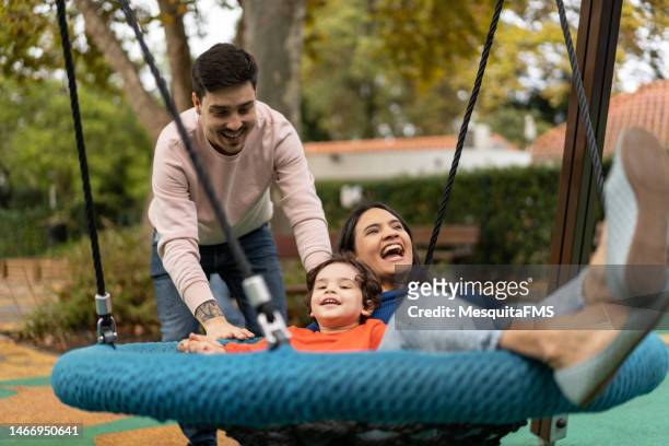 people on public park swing - young couple with baby stock pictures, royalty-free photos & images