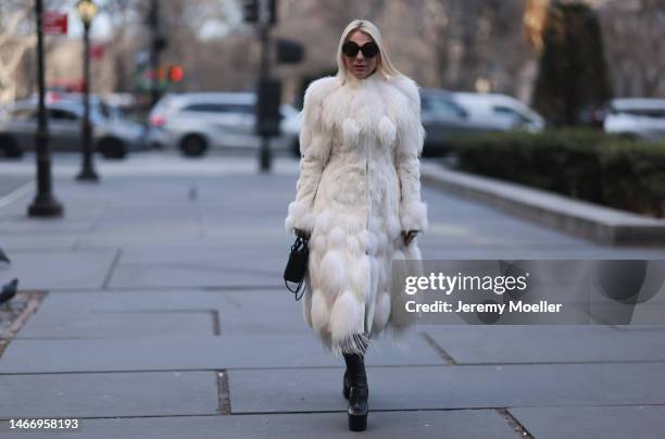 Corina Mihaila Larpin seen wearing Linda Fargo black sunglasses, Alexander McQueen white fur long coat, black leather leggings, YSL black leather...