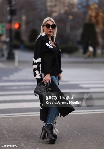 Corina Mihaila Larpin seen wearing Linda Fargo black sunglasses, Schiaparelli black long coat with white ornament print pattern, R13 dark blue...