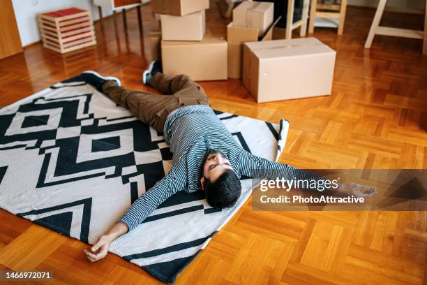 handsome young man moving to a new home - flattened man stock pictures, royalty-free photos & images