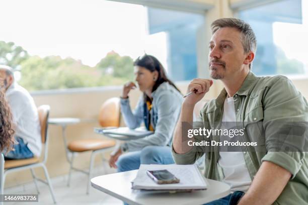 studente universitario adulto che presta attenzione in classe - real people foto e immagini stock