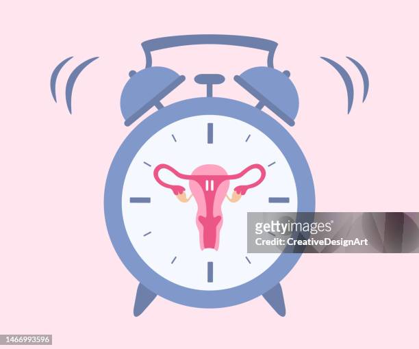menopause concept with uterus and alarm clock - menstruation stock illustrations