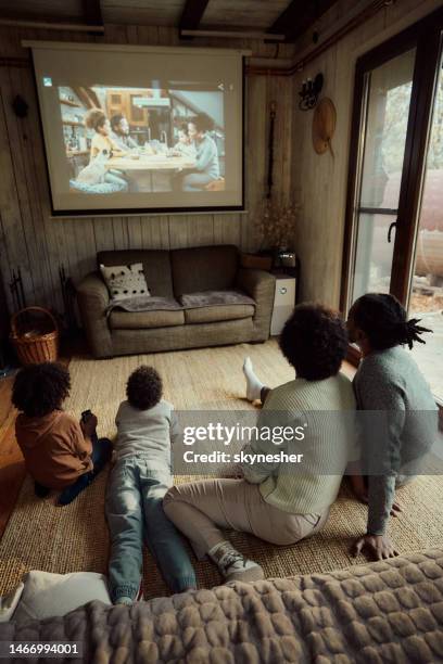 movie time at home! - family watching tv from behind stockfoto's en -beelden