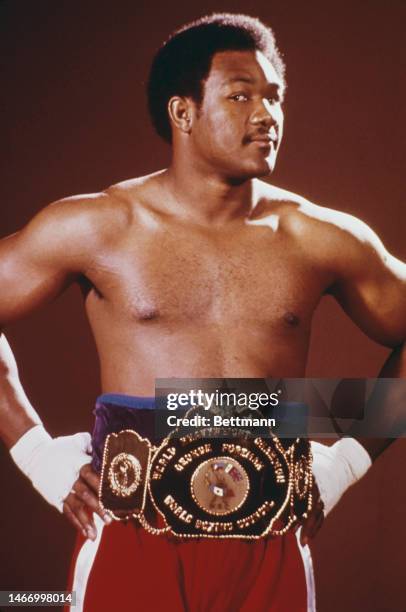 Heavyweight boxing champion George Foreman shows off his championship belt during a training session , October 1974.