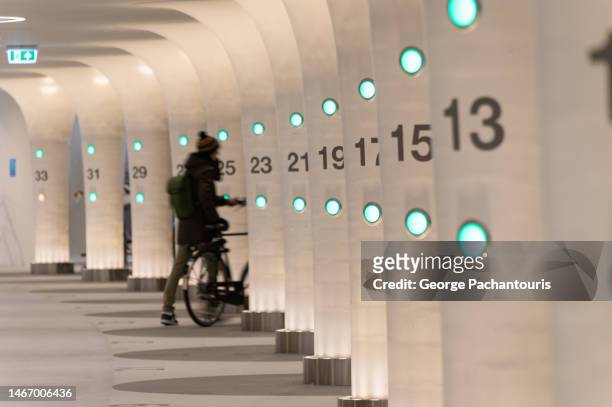 a cyclist in the underwater bicycle parking in amsterdam, holland - centraal station stockfoto's en -beelden