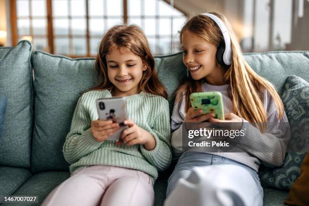 digital natives using phones at home - young tiny girls stock pictures, royalty-free photos & images