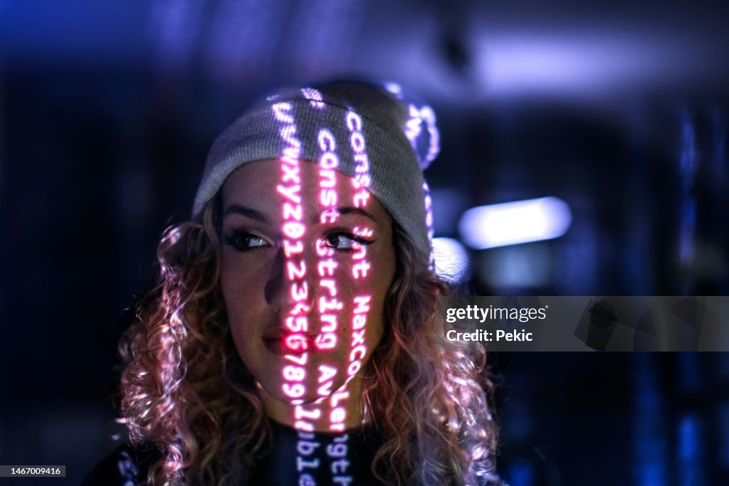 Computer code projected on young woman's face