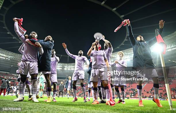 Players of Monaco celebrate their victory in front of fans after the UEFA Europa League knockout round play-off leg one match between Bayer 04...