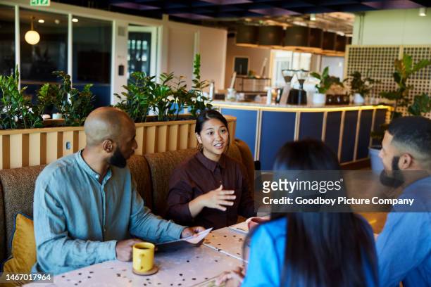 Smiling businesspeople having a meeting over coffee in an office cafeteria