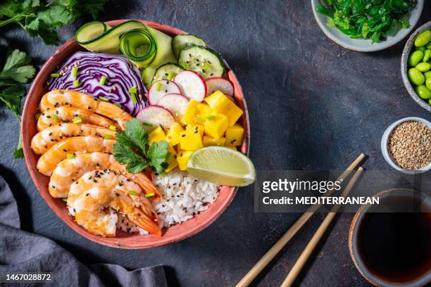 shrimp poke bowl on dark gray with mango, avocado, radish and carrot - shrimp edamame stock pictures, royalty-free photos & images