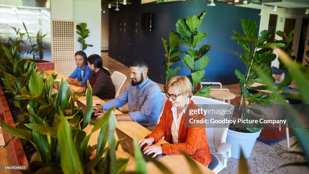 Diverse group of smiling businesspeople working at table in a modern office