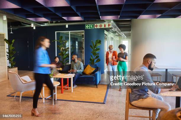 Diverse businesspeople working in the busy lounge of an office
