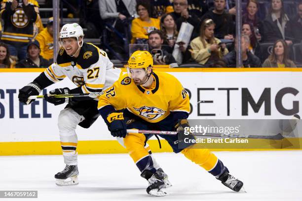 Hampus Lindholm of the Boston Bruins vies for position against Tommy Novak of the Nashville Predators during the third period at Bridgestone Arena on...