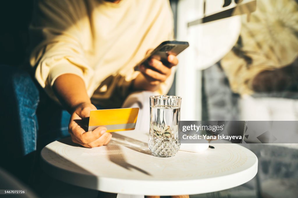 Woman using a credit card to pay online bills using mobile application