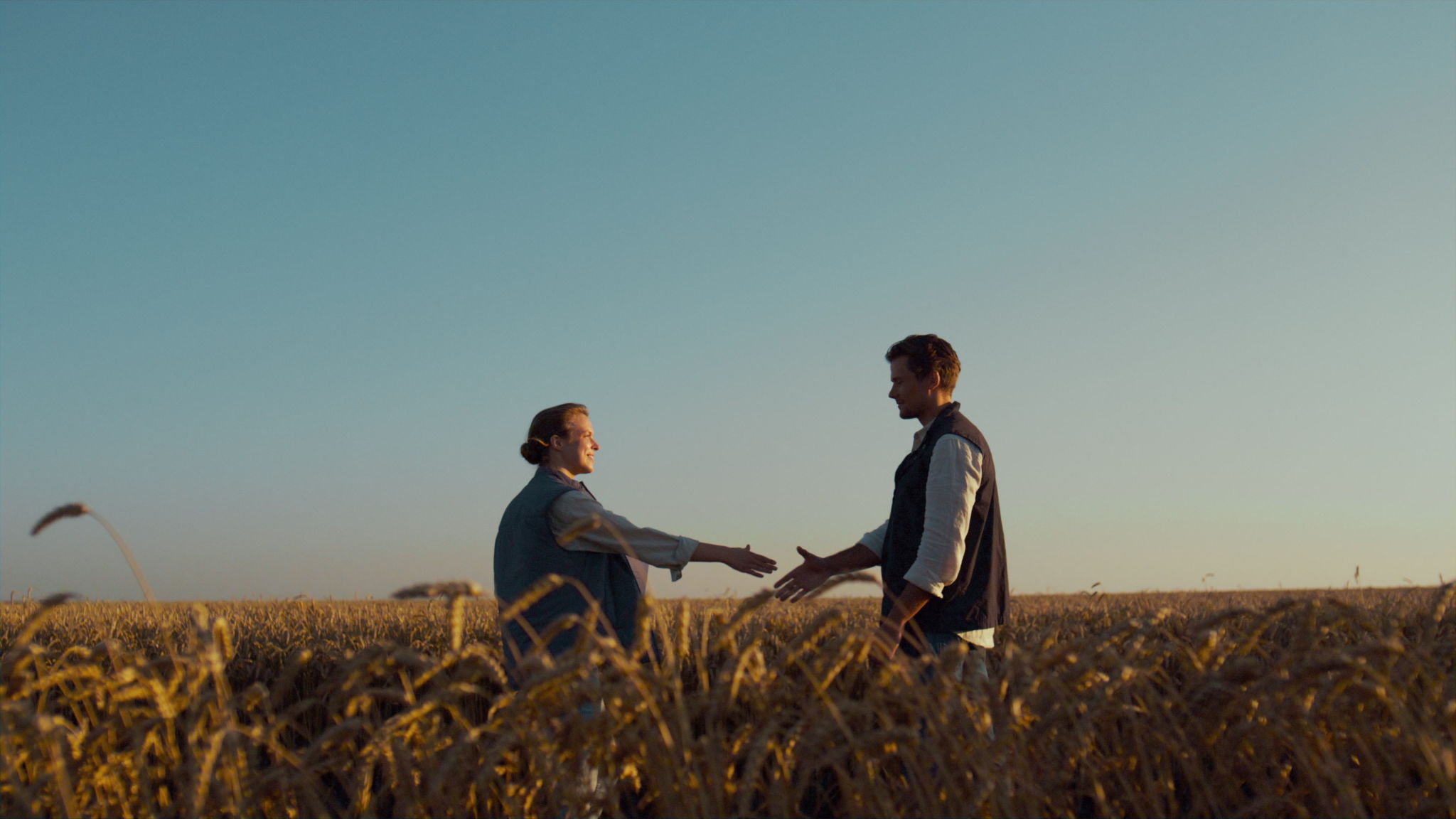 Farmers meeting wheat field in golden sunlight. Agronomists discussing agreement Farmers meeting wheat field in golden sunlight. Agronomists discussing agreement