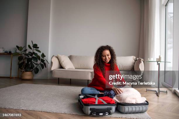 a dark-skinned girl collects a suitcase in the room. drive. journey. business trip. packing checklist. - passport open stock pictures, royalty-free photos & images