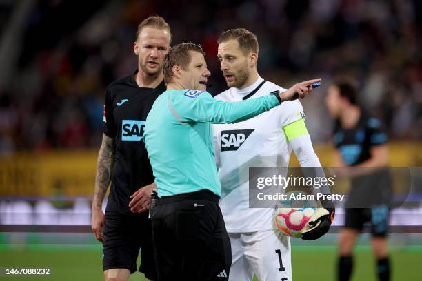 Oliver Baumann of TSG Hoffenheim talks to referee Patrick Ittrich during the Bundesliga match between FC Augsburg and TSG Hoffenheim at WWK-Arena on...