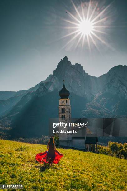 young tourist woman enjoys visiting st. valentin church, castelrotto kastelruth with mount schlern in the background in dolomites, south tyrol, italy - bolzano stock pictures, royalty-free photos & images