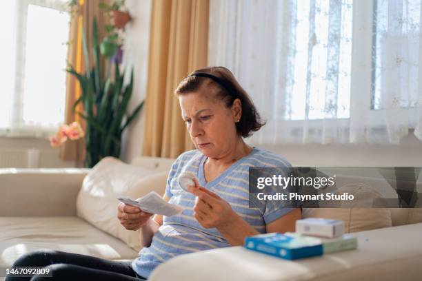 menopausal mature woman checking patient information leaflet for her medicine - hormone therapy stock pictures, royalty-free photos & images