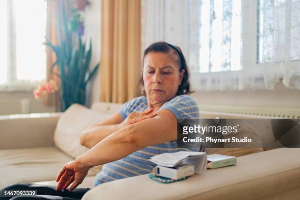 menopausal mature woman is doing hormone replacement therapy - hrt pill stockfoto's en -beelden