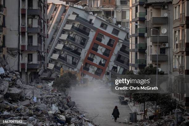 Woman walks on a street amid destroyed buildings on February 17, 2023 in Hatay, Turkey. A 7.8-magnitude earthquake hit near Gaziantep, Turkey, in the...