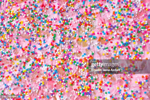 colorful sprinkles background pink birthday cake closeup rainbow nonpareils - alcorza fotografías e imágenes de stock