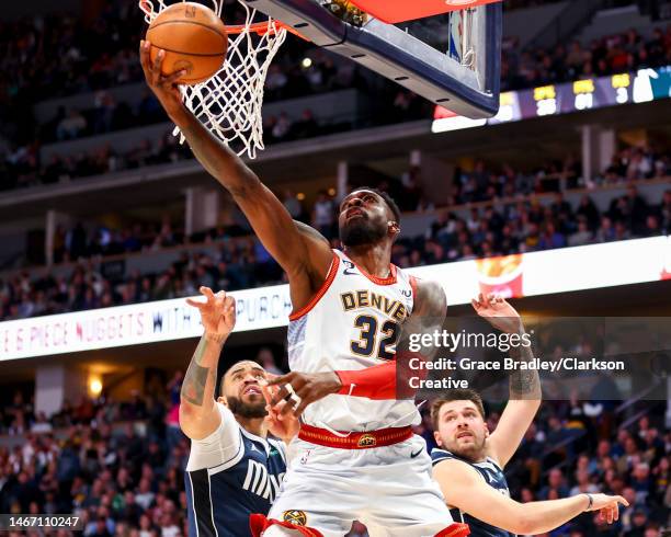 Jeff Green of the Denver Nuggets drives past JaVale McGee and Luka Doncic of the Dallas Mavericks during the second half of the game at Ball Arena on...